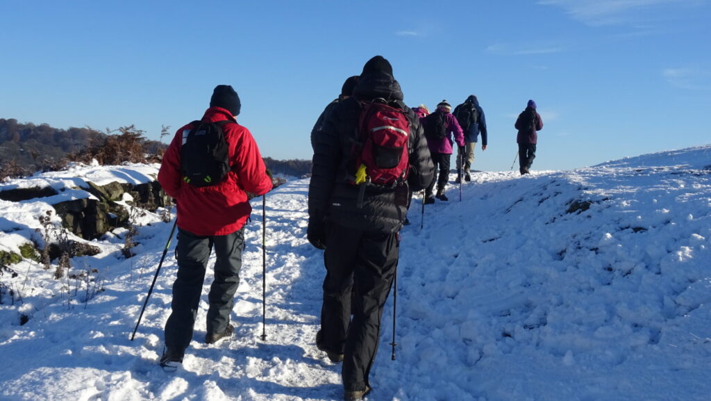 Members of Derbyshire Dales climbing a snowy hillside